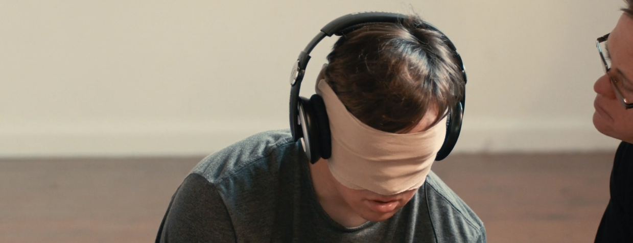boy blindfolded with headphones on